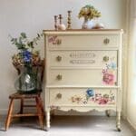 dresser painted in tan clay furntiure paint with flowers and a vase resting beside it