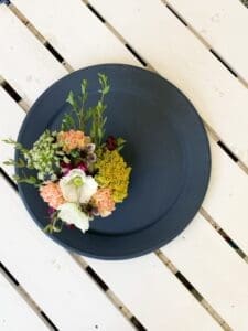 top down view of flowers and platter painted in dark navy clay furniture paint