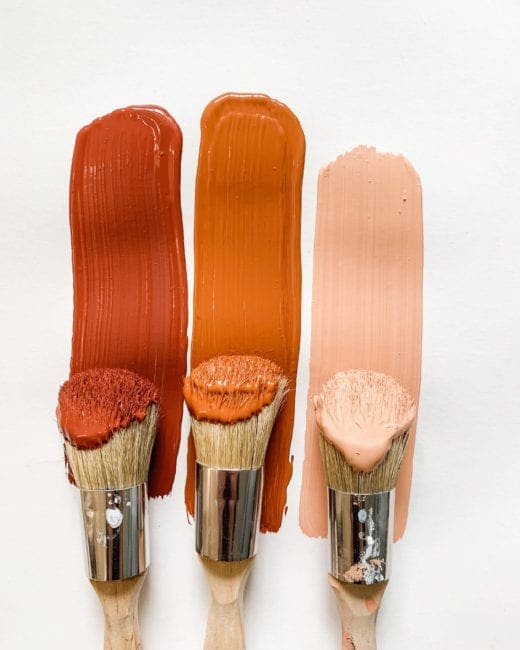 three paint brushes with various shades of orange, pink and red clay furniture paint