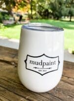 mudpaint branded coffee cup tumbler sitting on a wooden table